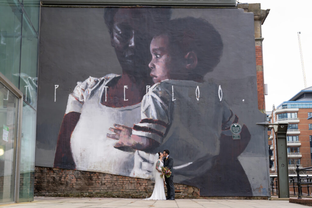 Bride and groom in front of graffiti near Manchester Hall