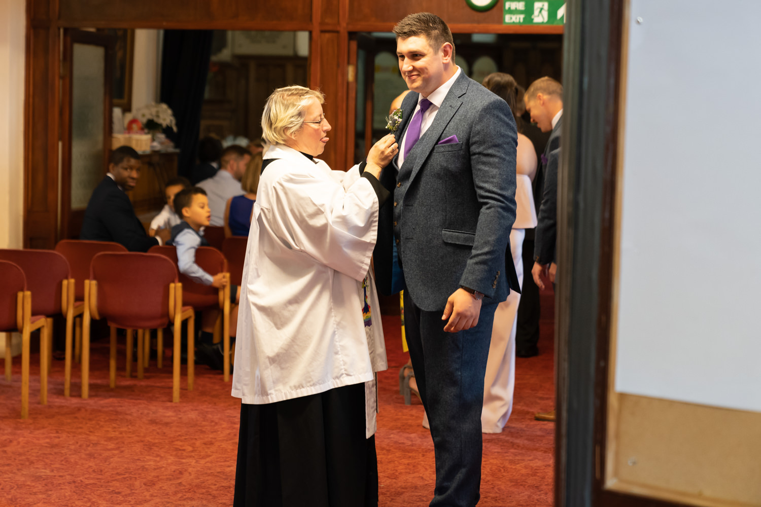 Vicar fixing the grooom's buttonhole