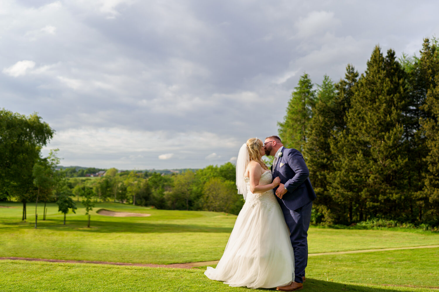 Bride and groom kissing on Ashton Golf Course
