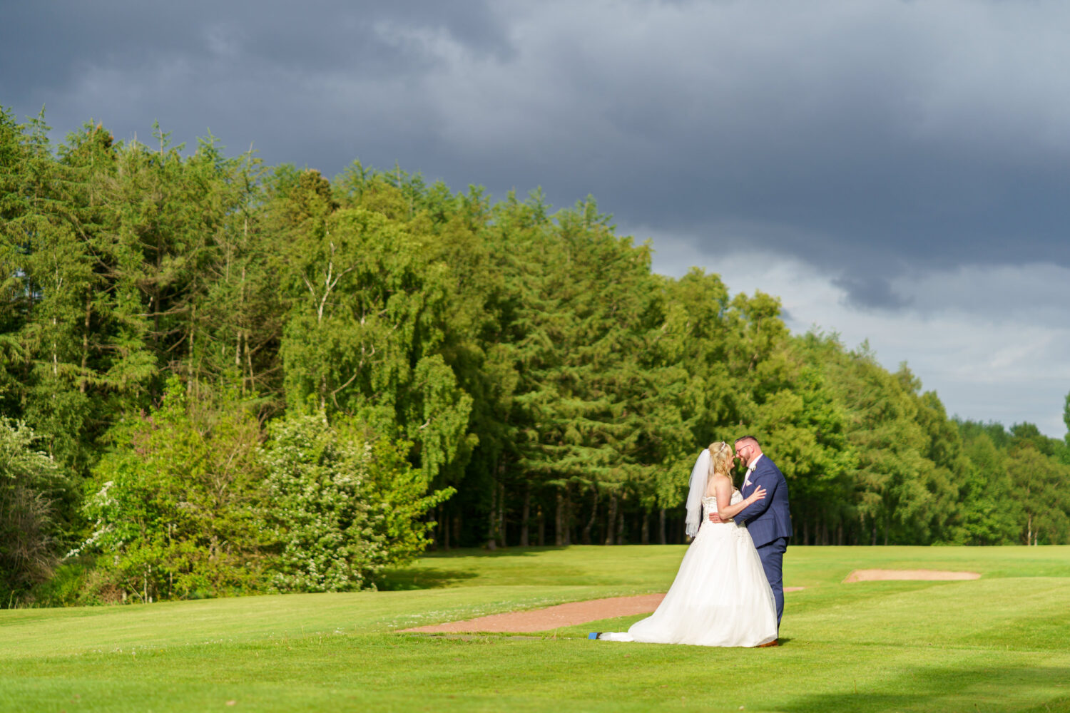 Bride and groom in glorious light on the golf club in Ashton