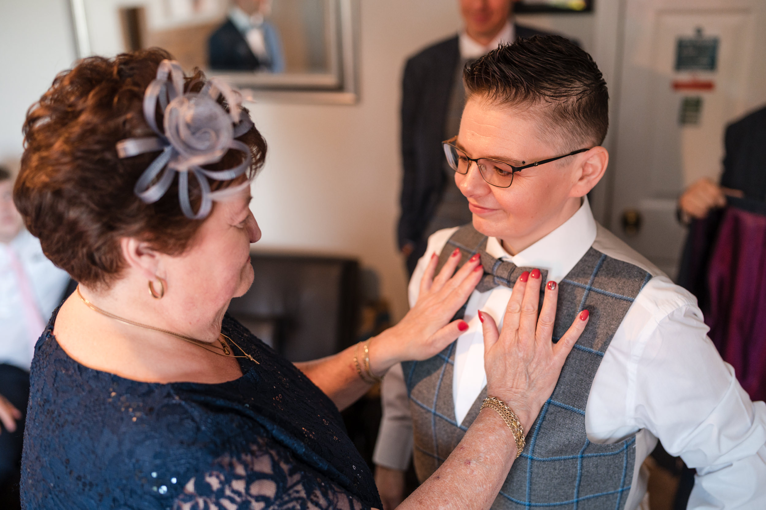Bride's bowtie being smoothed. Grains Bar Hotel.
