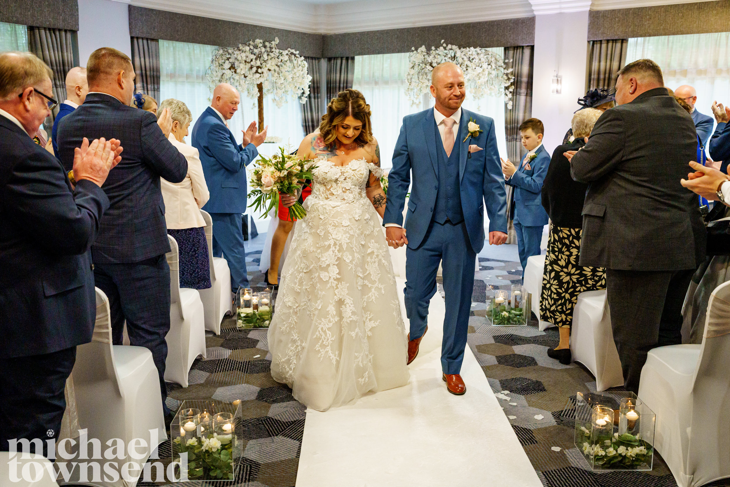Bride and groom walking down the aisle together at Norton Grange