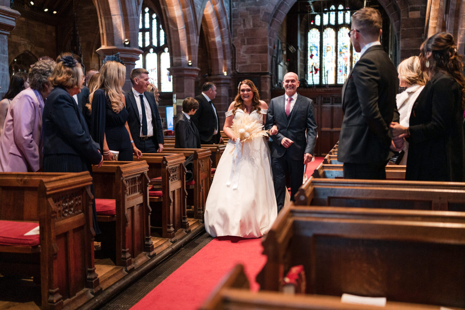The bride and her dad walking down the aisle at All Saints Church