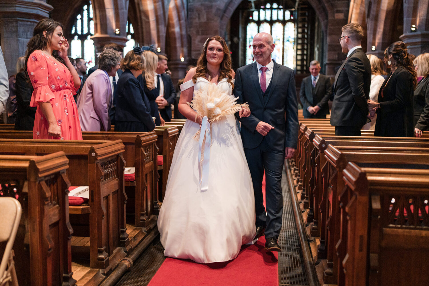 The bride and her dad walking down the aisle at All Saints Church