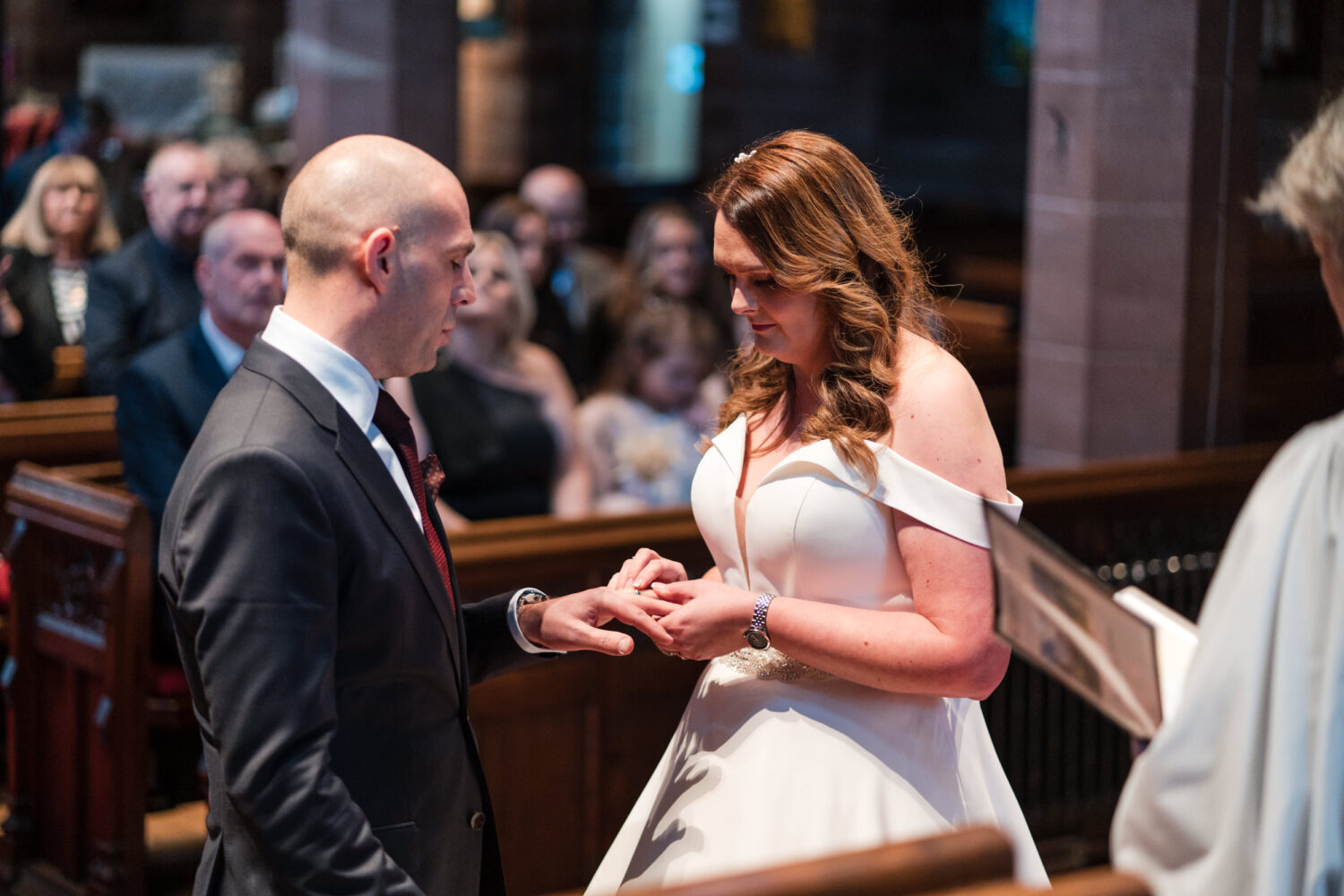 The bride putting the grooms ring on him