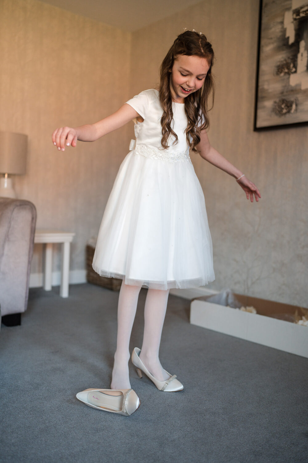 Bride's daughter trying on the bride's shoes.
