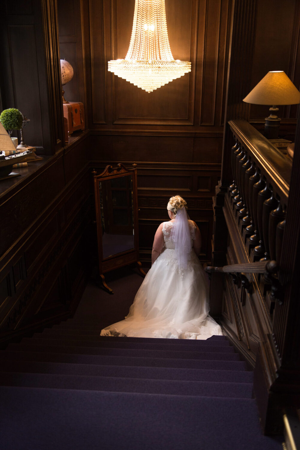 Bride stood under the chandelier at Eaves Hall