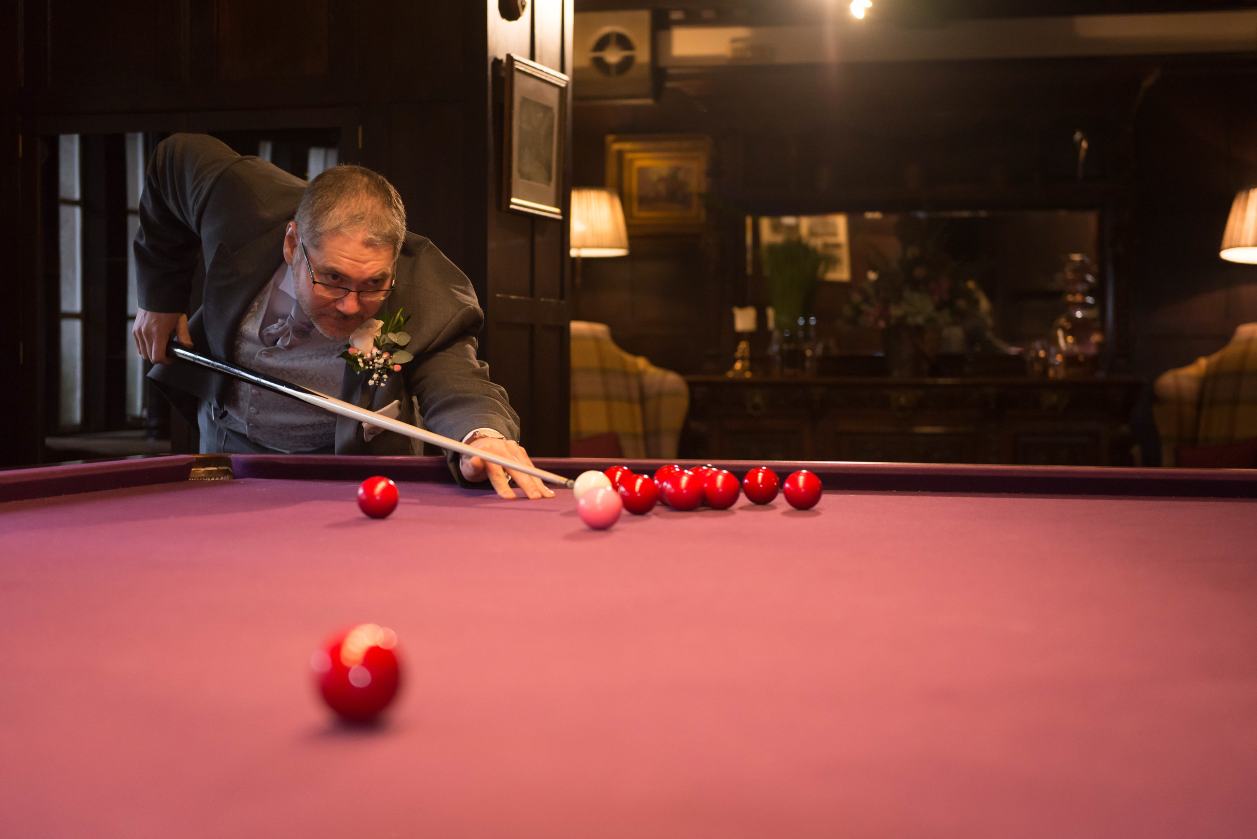 Groom playing billiards at Eaves Hall