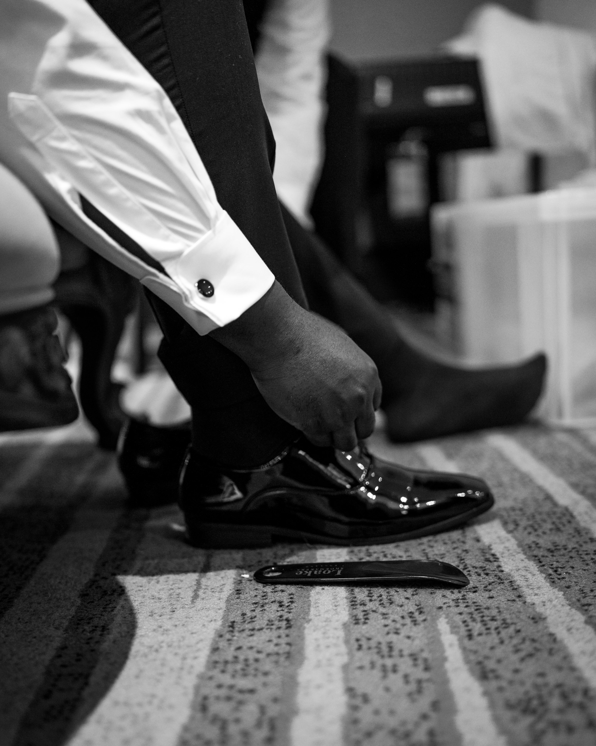 Groomsman tying his shoes at the Stanneylands