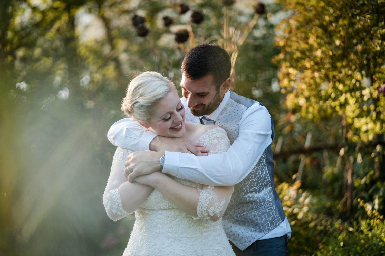 Bride and groom embracing in the gardens at Brantwood