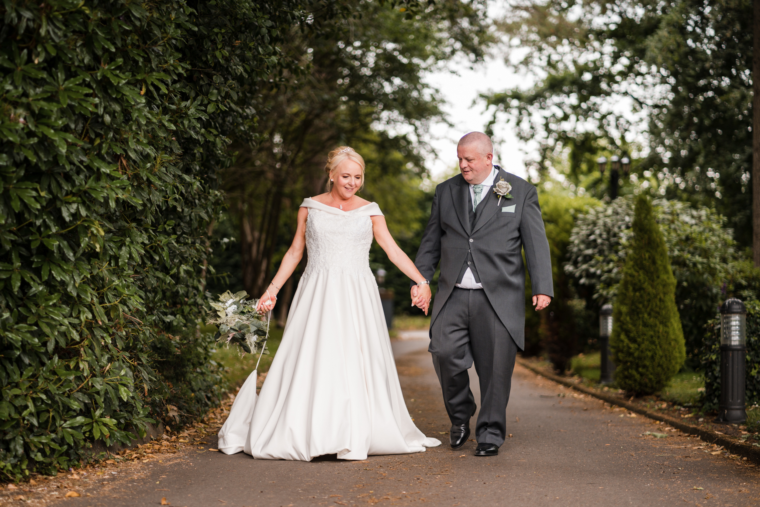 Bride and groom walking together in the gardens of Briars Hall