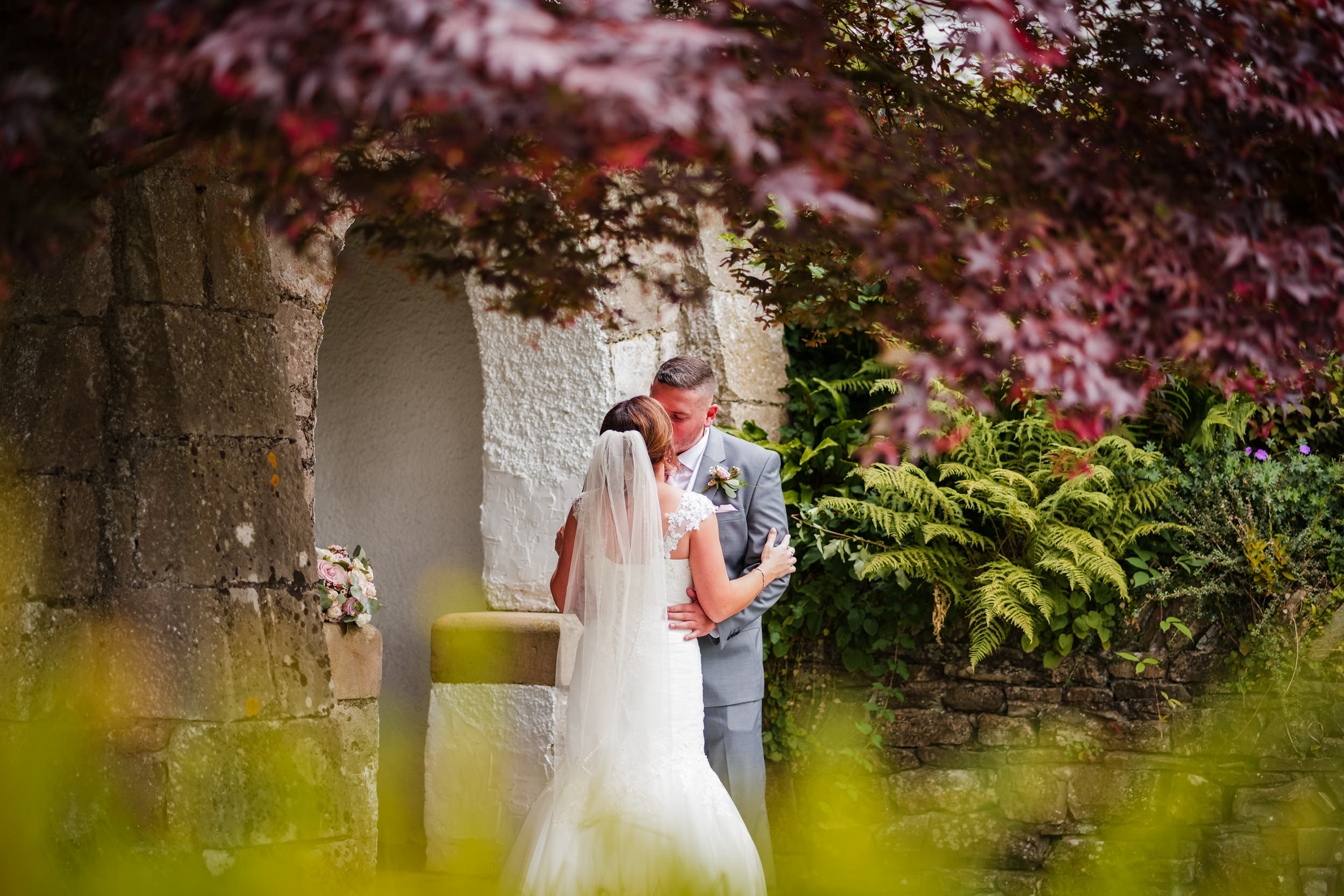 Bride and groom kissing in the grounds of Castle Green Hotel