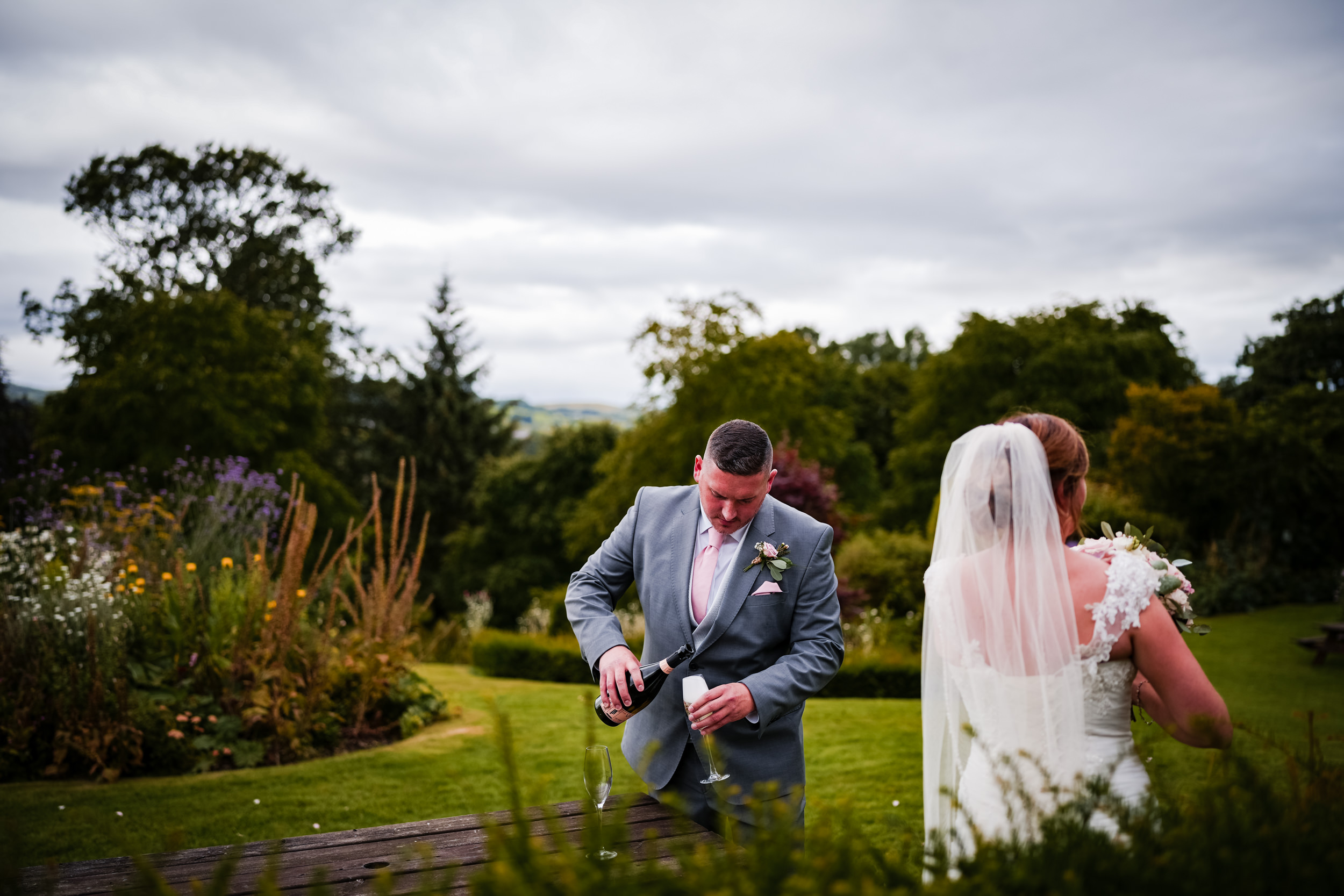 Groom pouring champagne at Castle Green