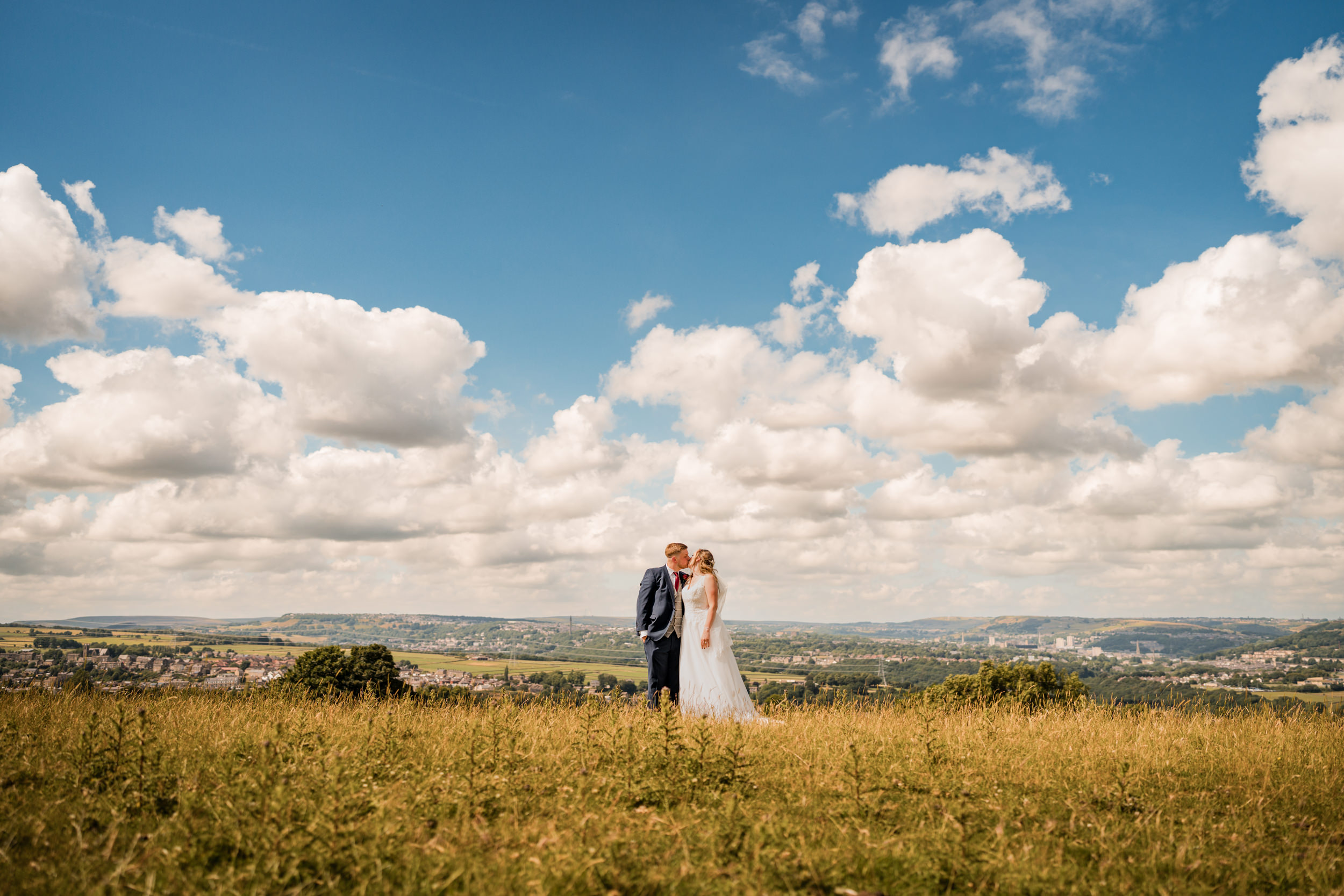 Couple kissing in a field near Cedar Court