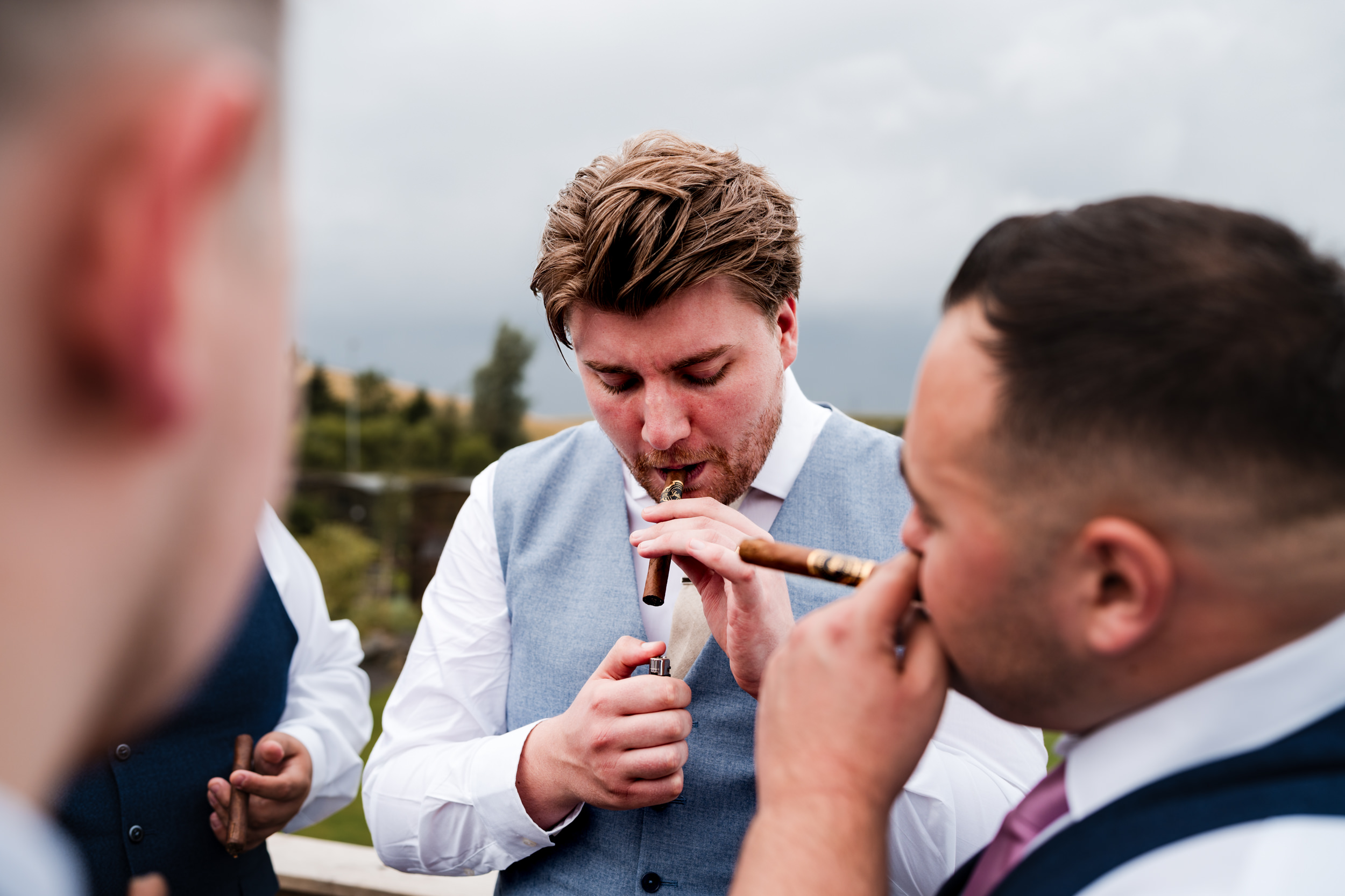 Groom lighting his cigar at Grains Bar