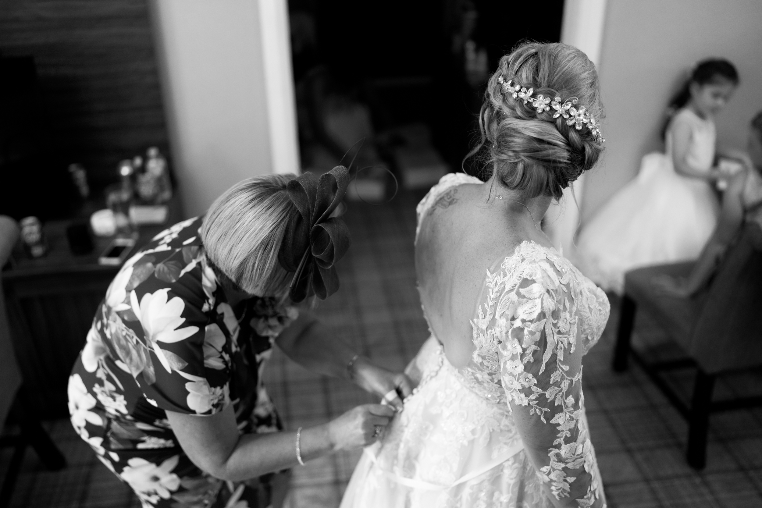 Bride having her wedding dress fastened at Norton Grange