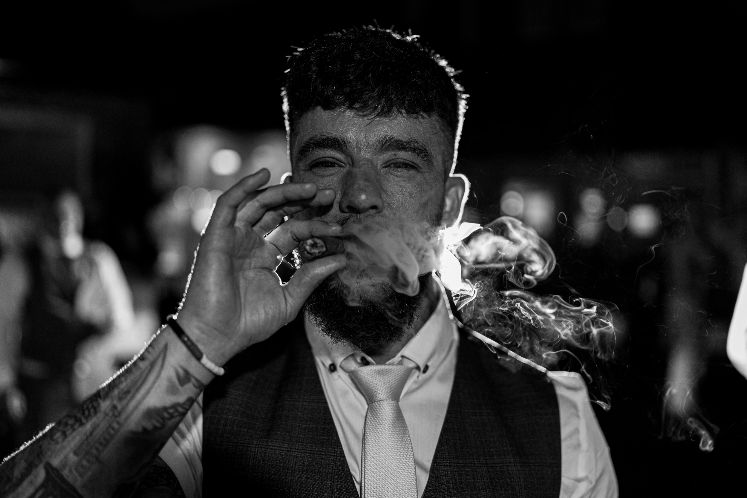 Black and white photo of groom smoking a cigar at Norton Grange.