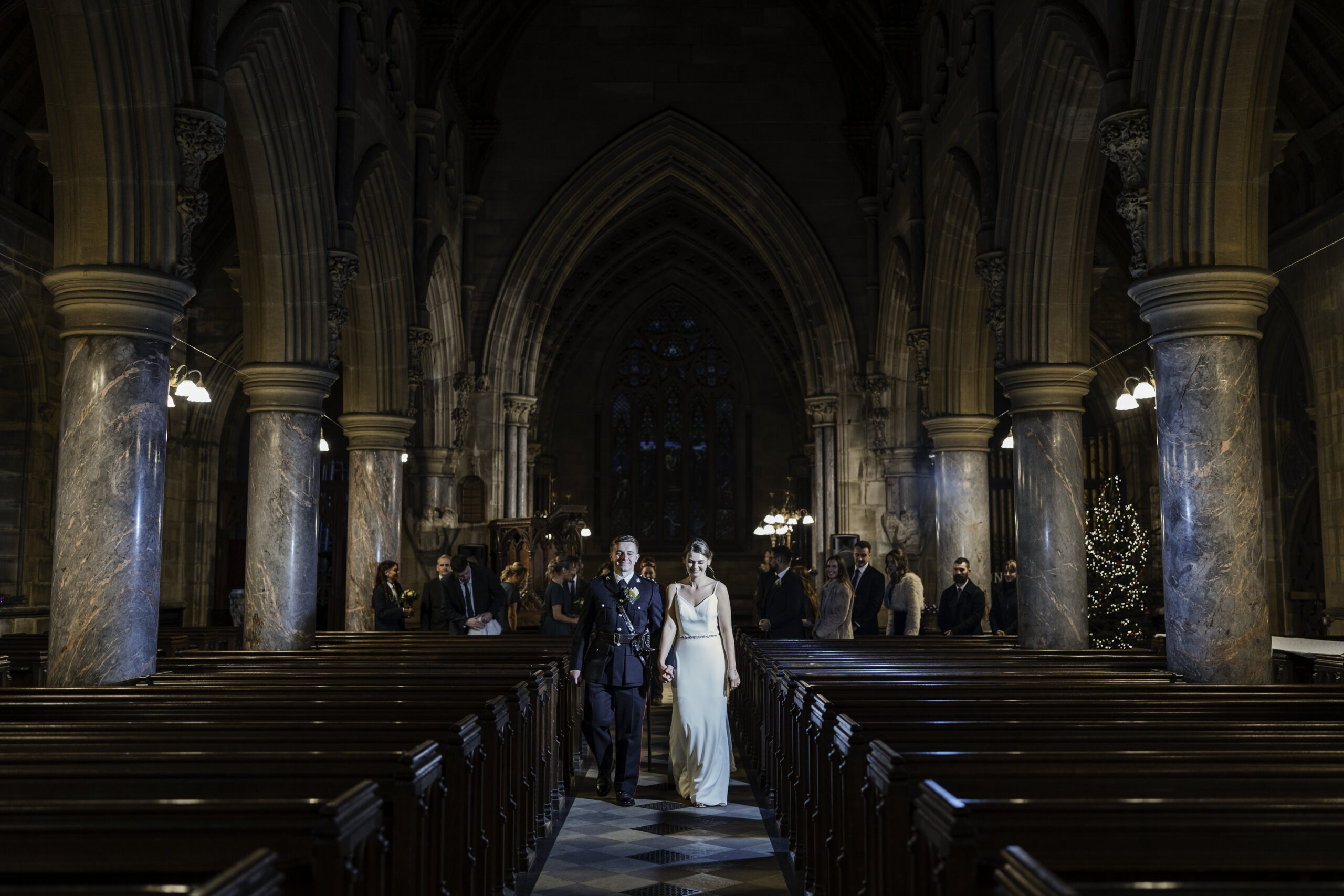 Couple walking out together at a church near Fielden Hall.