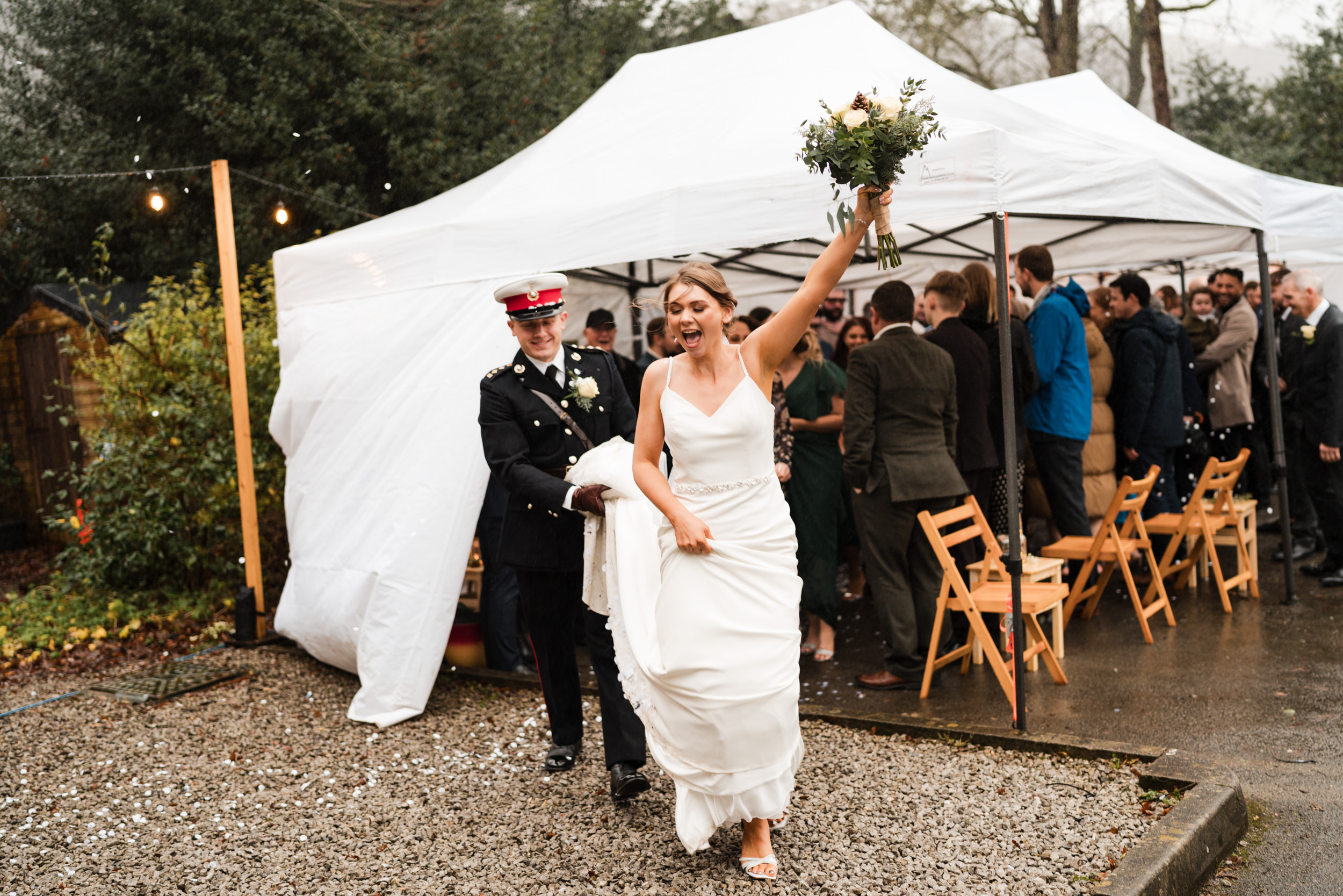 Bride lifting her bouquet into the air. Fielden Hall