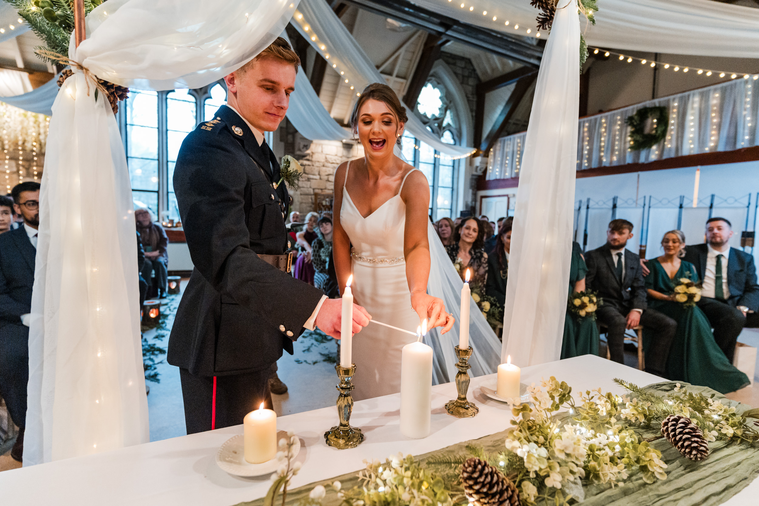 Couple lighting candles during their ceremony. Fielden Hall.