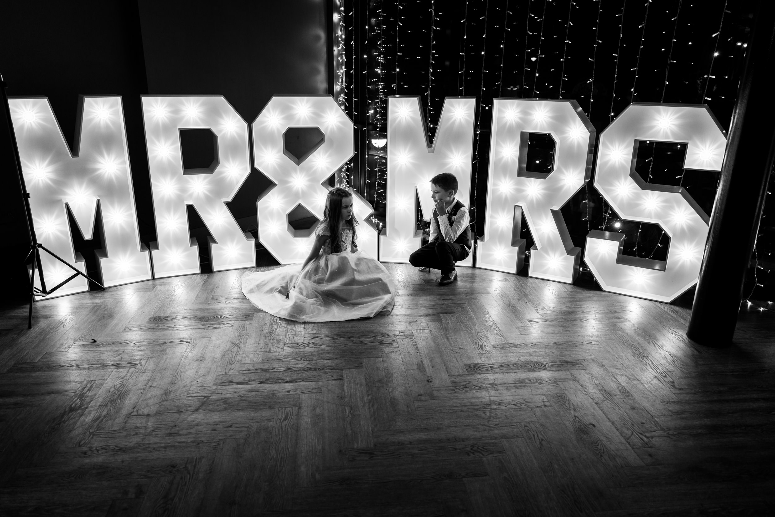 The couples' children in front of the Mr and Mrs sign