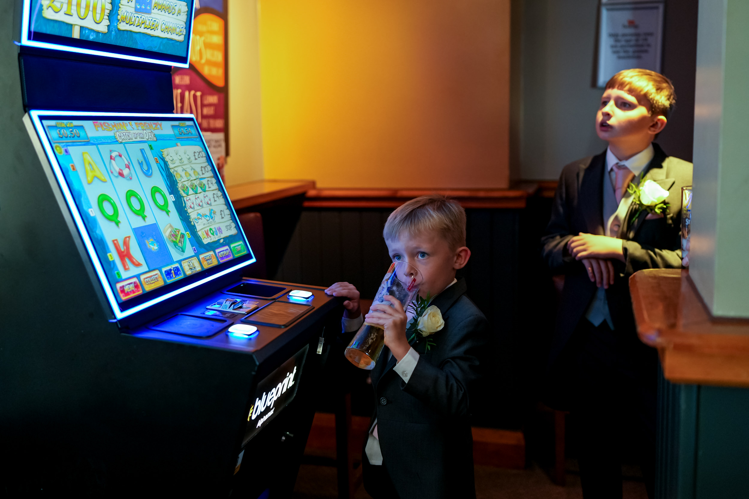 Paige boy holding a beer and pretending to play the fruit machine