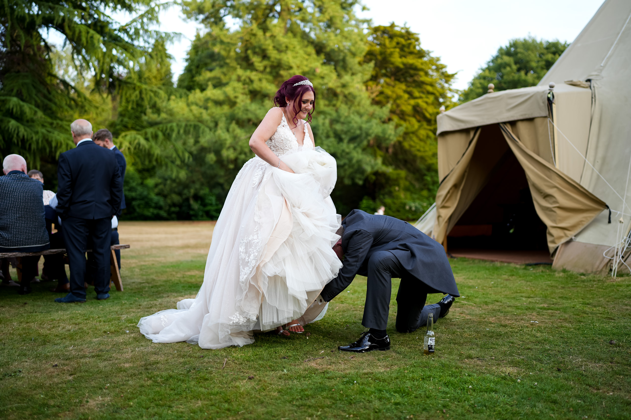 Groom fastening the bride's shoes