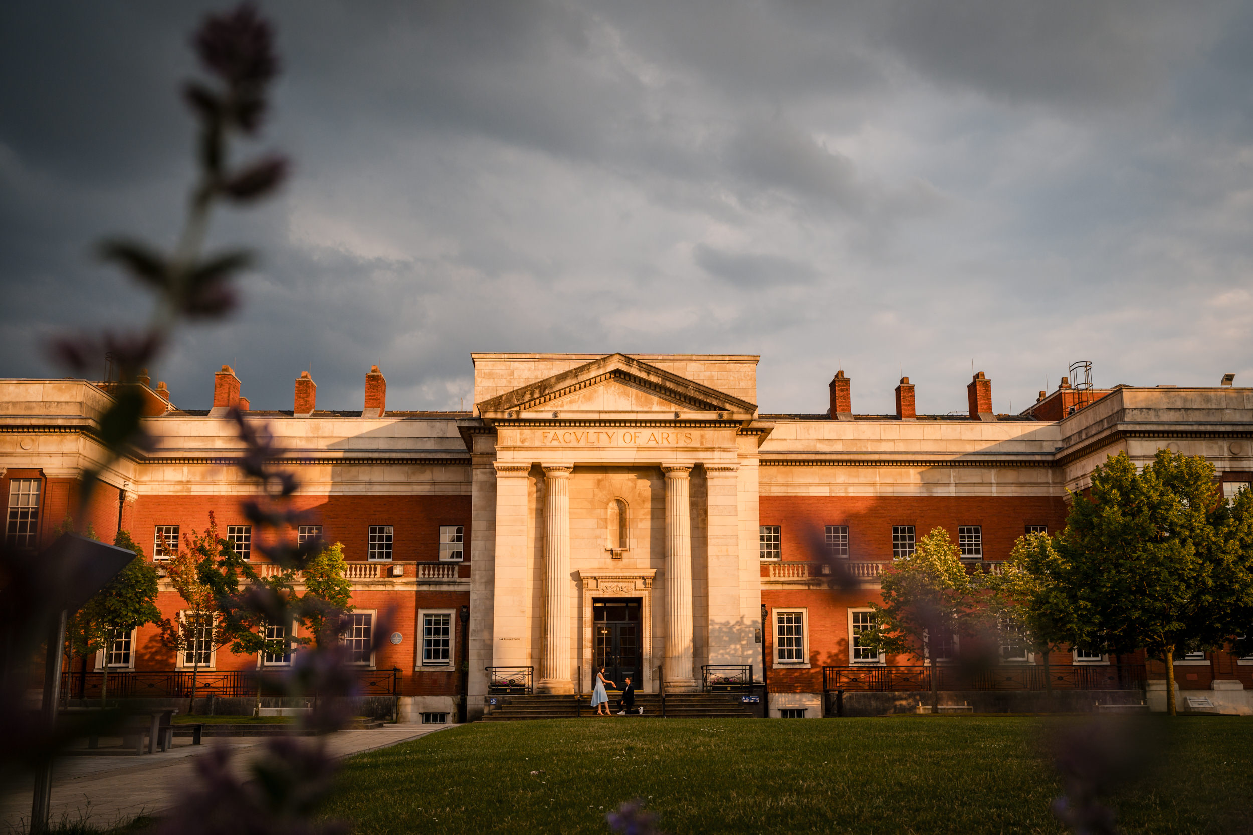 The couple in front of the Faculty of Arts at the University of Manchester.