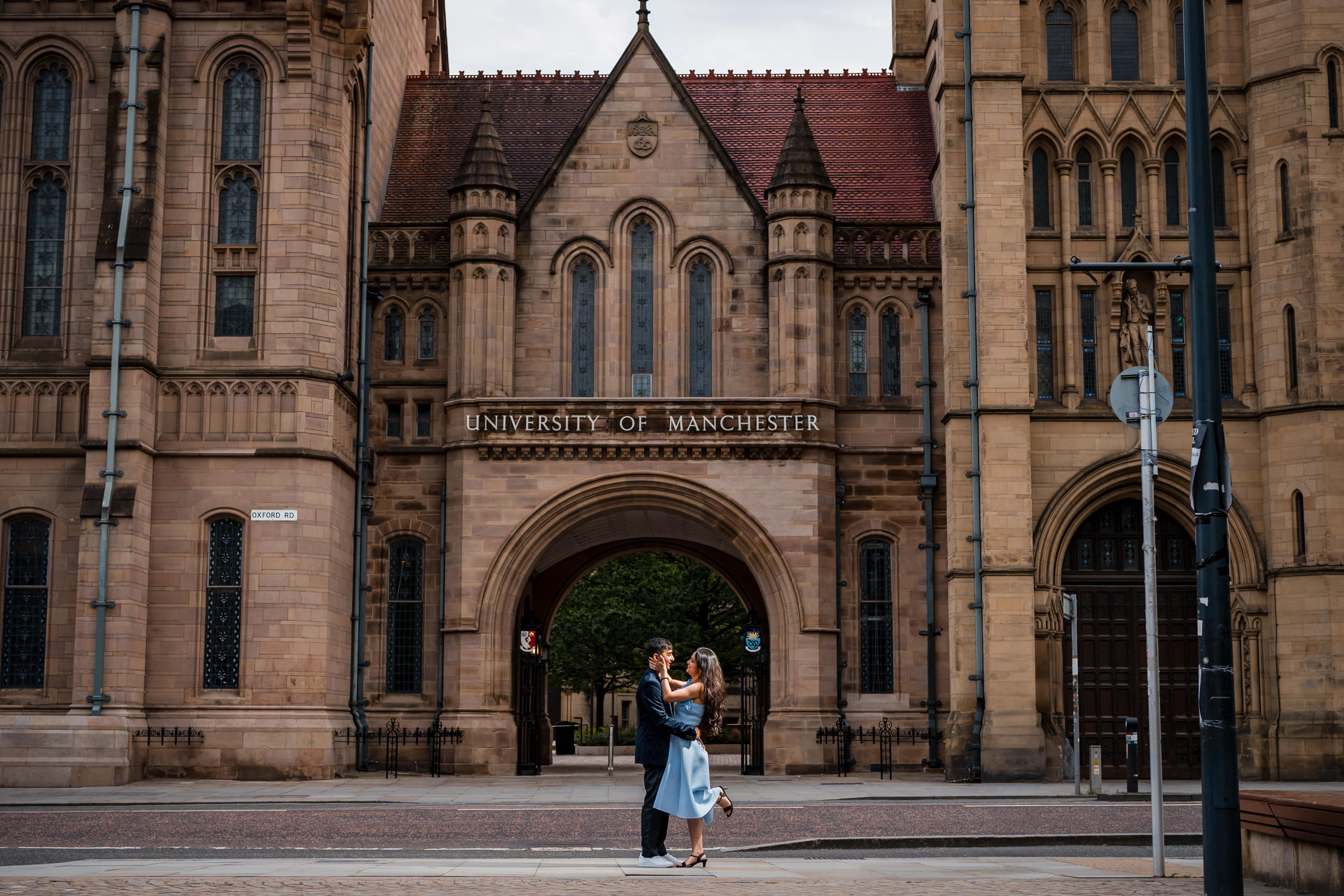 Couple embracing outside the University of Manchester.