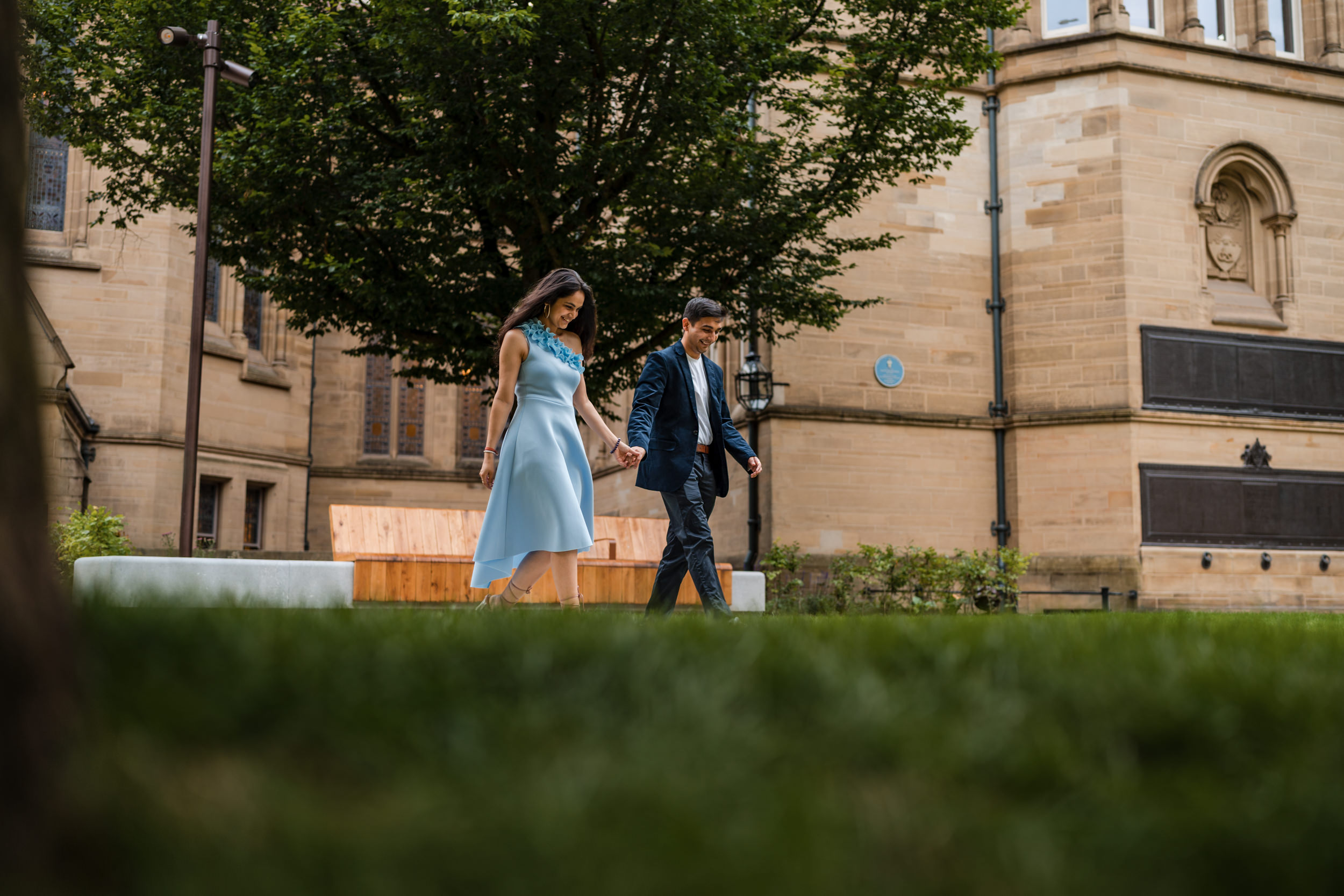 Couple walking across the Old Quadrangle at the University of Manchester.