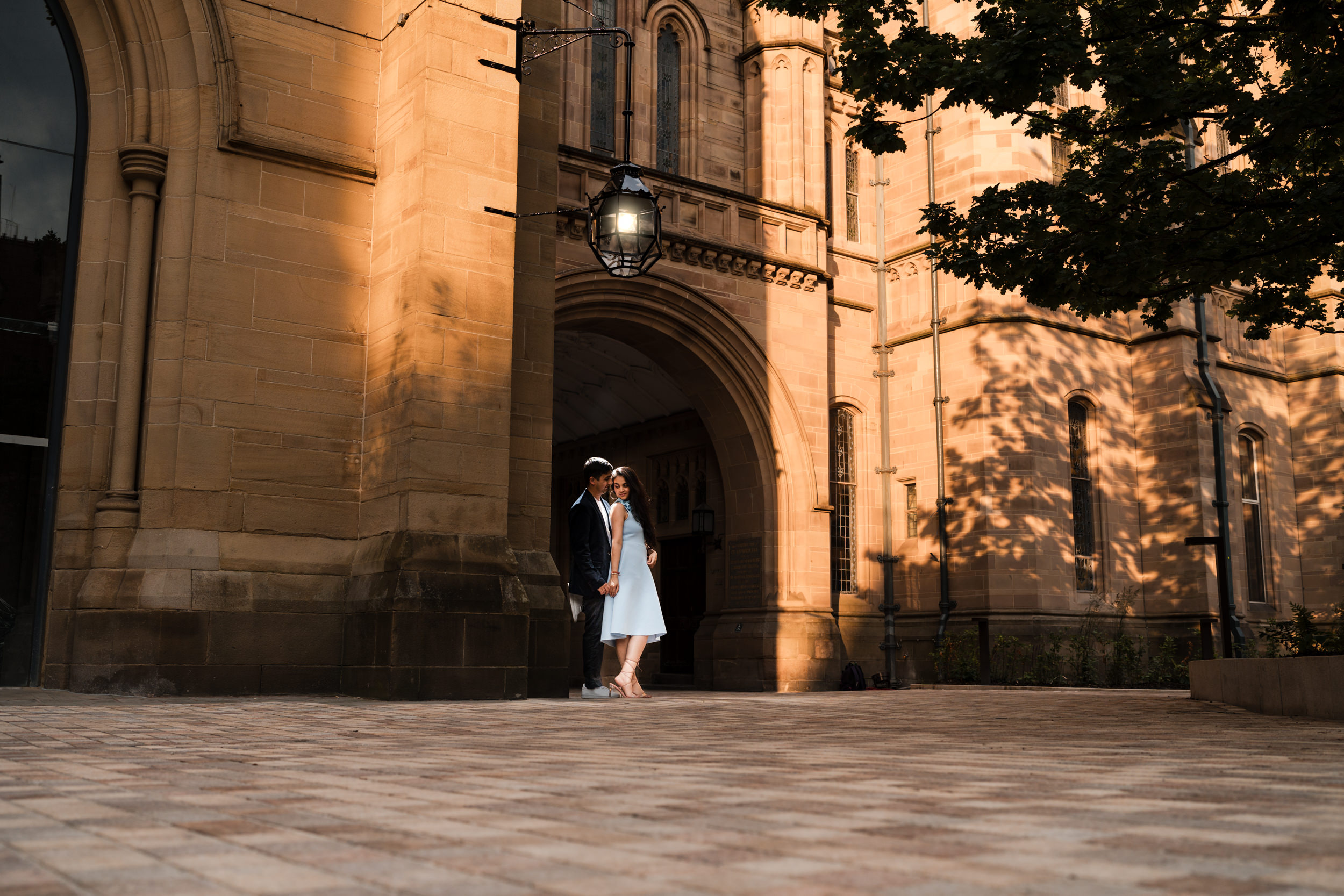 Couple under a light in the Old Quadrangle at the University of Manchester.