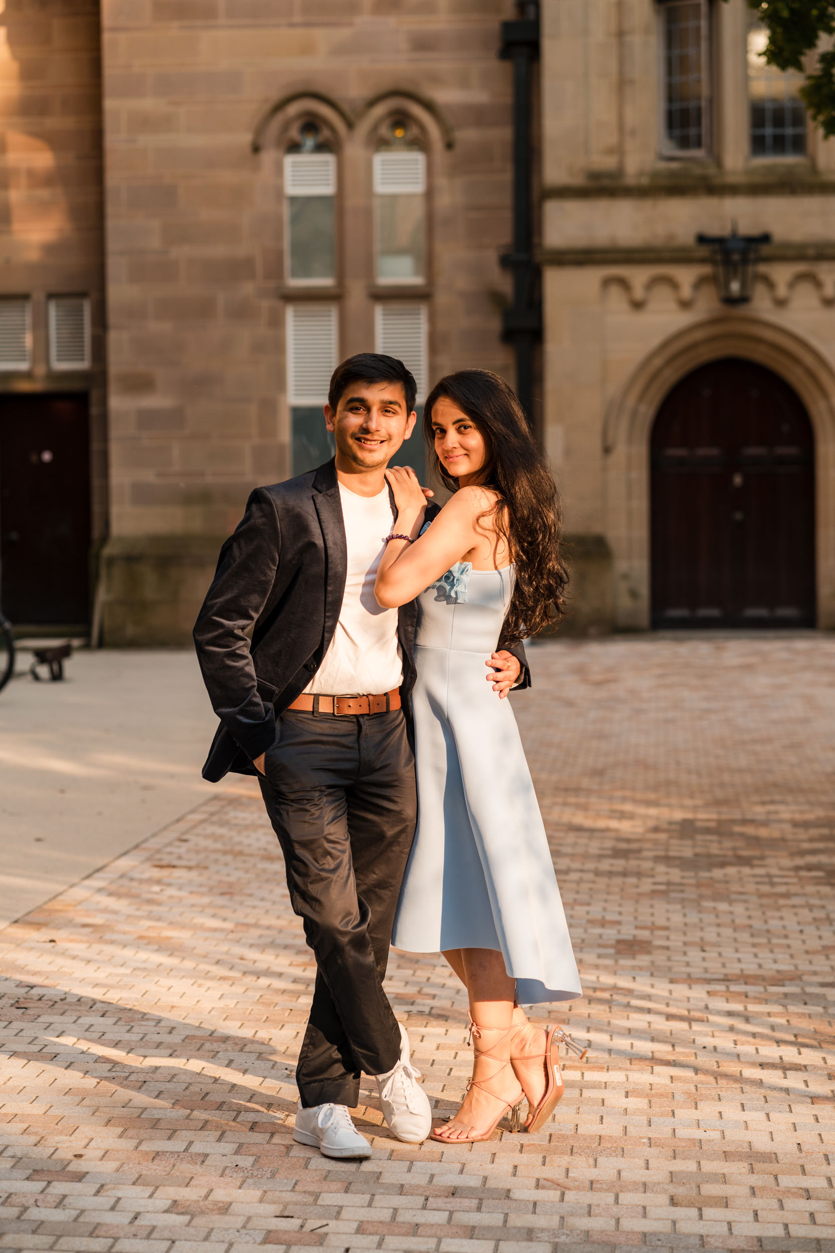 Couple in a beam of sunlight in the Old Quadrangle at the University of Manchester.