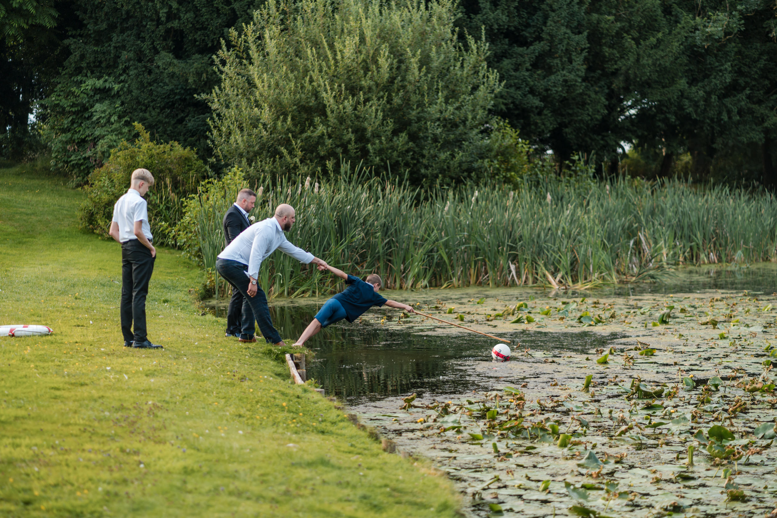Kids getting a ball out of the lake
