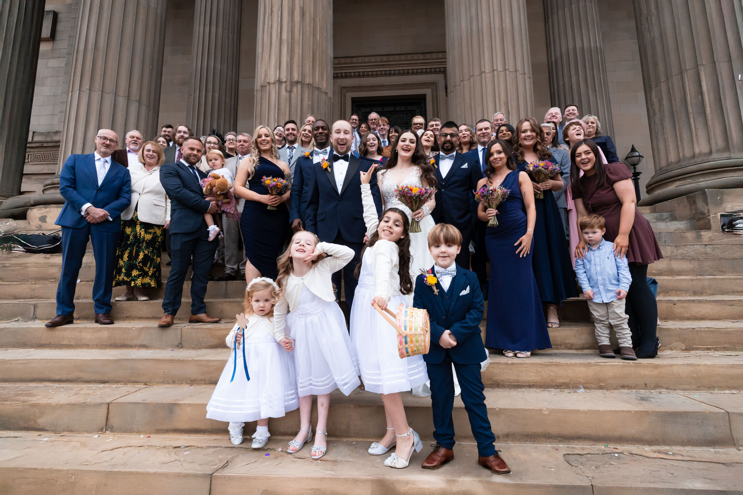 Bride, groom, and all their wedding guests on the steps of St Georges Hall